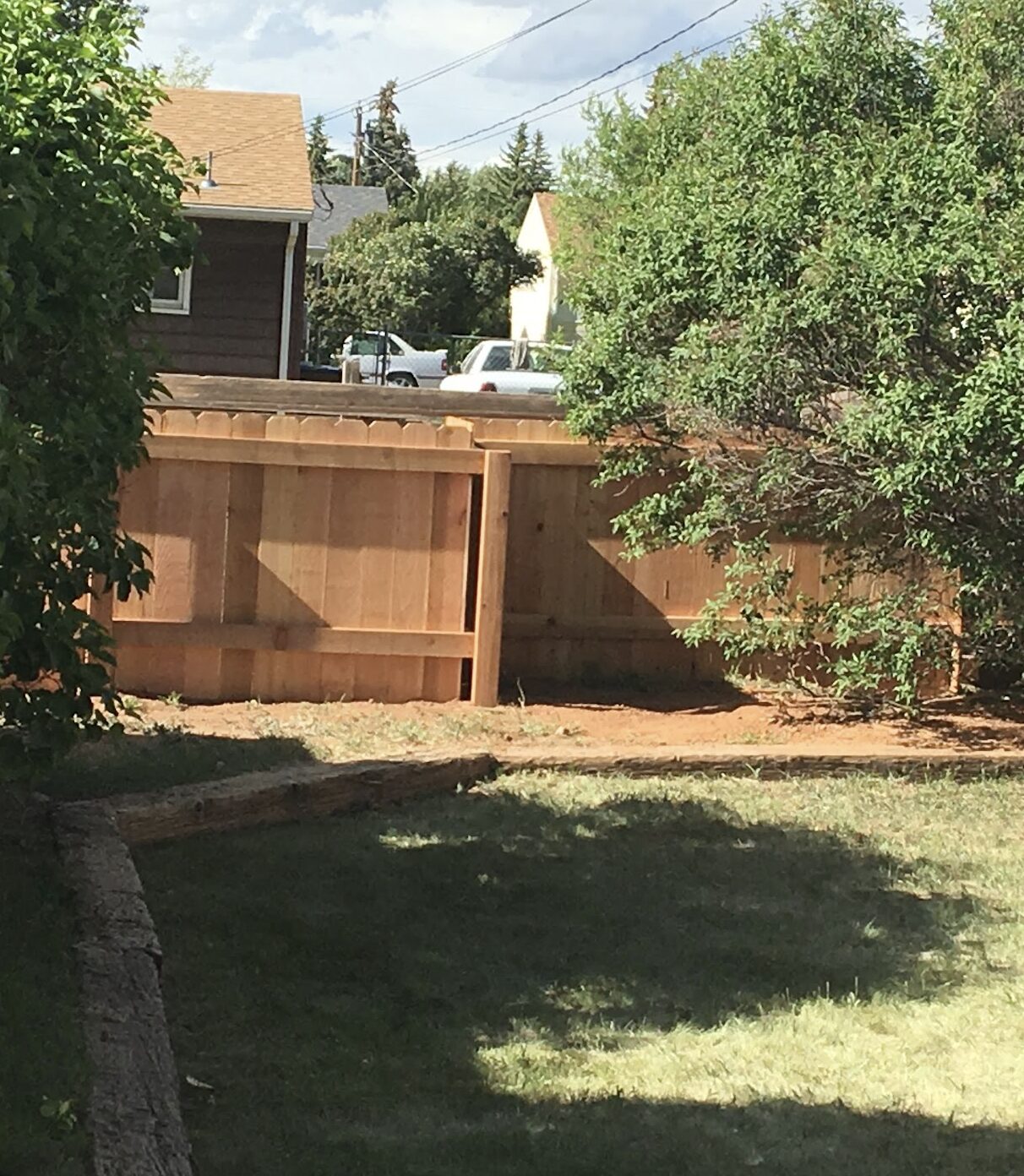 Completed wood fence enclosing a green lawn